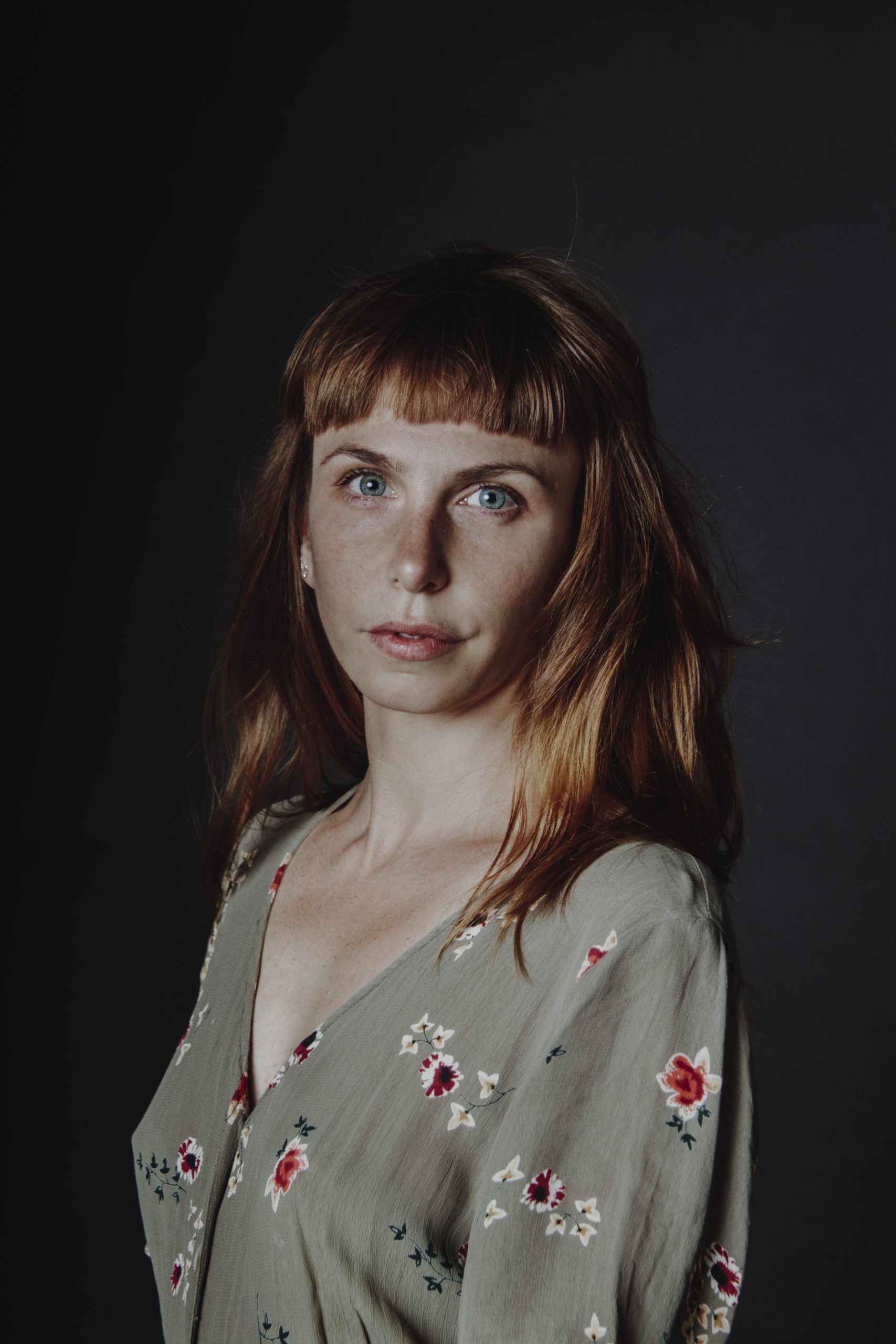 Retrato de Carmela sobre fondo oscuro.